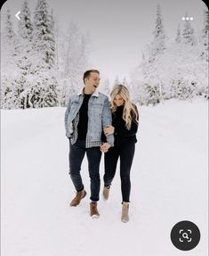 a man and woman walking in the snow