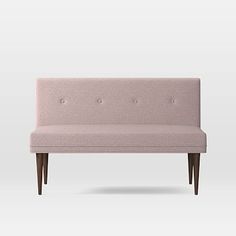 an upholstered pink bench with wooden legs and buttons on the armrests