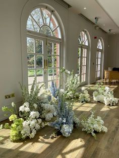 flowers on the floor in front of large windows