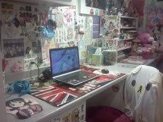 a laptop computer sitting on top of a desk in a room filled with comic books