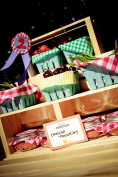 an assortment of cupcakes and pies in baskets on a wooden box with ribbons