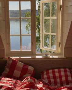 there is a red and white checkered bed in front of two windows with the words this morning on it