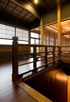 an empty room with wooden floors and windows in the center is lit up by lights