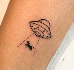 a small tattoo on the arm of a woman with an astronaut's helmet and dog