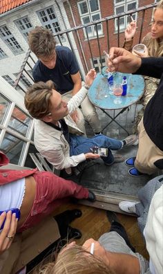 a group of people sitting around a table on top of a roof next to each other