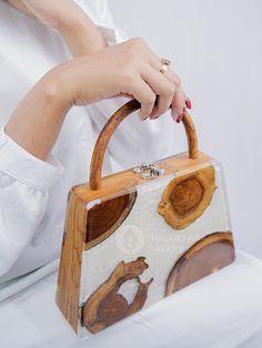 Nusantara Cari Handmade Wooden Teakwood Handbag, Top Handle Bag with Epoxy Resin, Women Fashion Handbag, Women Gift Materials: Teak Wood, Epoxy Resin, Premium Gail for Inner 📐Dimensions: Length: 24 cm / 9.4" Width: 6.5 cm / 2.6" Height: 25 cm / 9.8" 👜 Unique Design: One pattern for each handbag. The item received will have a different pattern from the picture since it's a natural wood. ✨ These wooden bags are made by hand, which means more attention to detail and higher quality items.  ✨ Eco-f Wood Bags Handmade, Brown Box Bag With Detachable Handle As Gift, Brown Box Bag With Detachable Handle For Gift, Rectangular Bags With Bamboo Handle For Gift, Rectangular Bag With Bamboo Handle As Gift, Rectangular Bag With Bamboo Handle For Gift, Bamboo Handle Tote Bag As Gift, Bamboo Handle Tote Bag For Gift, Gift Shoulder Bag With Top Carry And Round Handle