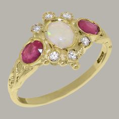 "This traditional accented trilogy ring is made completely of solid Gold, and is set with a central fiery Opal, encircled with six dazzling Cubic Zirconia and accompanied by two vibrant Rubies. The ring has a delicate design with a subtle band that is low profile and comfortable to wear, while the face of the ring is is eye catching yet elegant. The central Opal and the two Rubies are natural, earth-mined and therefore have to be individually selected before being hand set into this ring so that Red Ring Box, Trilogy Ring, Delicate Design, Ruby Diamond, Natural Earth, Natural Opal, Yellow Rose, Pink Tourmaline, Anniversary Rings