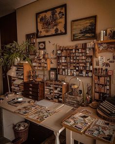 a room filled with lots of books and magazines on top of a table next to a potted plant