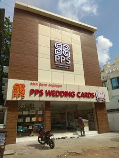 a motorcycle parked in front of a building with the words pgs wedding cards on it