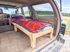 the back end of a van with a bed in it