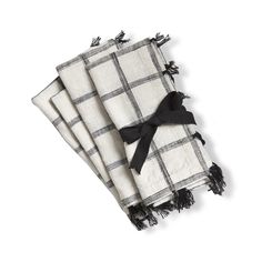 three black and white checkered napkins with tassels on each one side