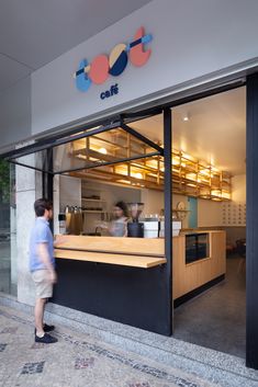 a man standing in front of a restaurant looking at the counter and food preparation area