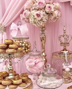 a table topped with lots of pink and gold desserts