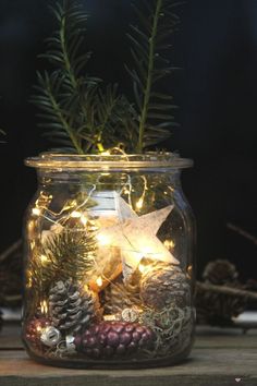 a mason jar filled with pine cones and lights