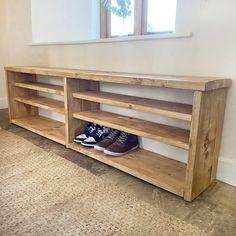 a wooden shelf with two pairs of shoes on it and a window in the background