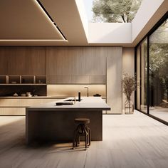 a kitchen with an island and stools in the center, surrounded by glass walls