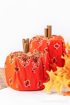 three orange pumpkins sitting on top of a table