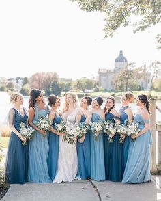 a group of women standing next to each other in front of a body of water