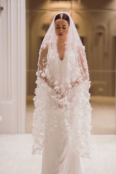 a woman in a white wedding dress and veil