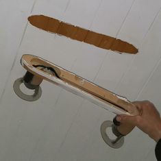 a person holding a skateboard in front of a wall that has been torn off