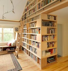 there is a book shelf with many books on it and a ladder to the top