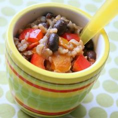 a bowl filled with rice and vegetables on top of a table