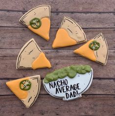 cookies decorated to look like pizza slices with the words nacho average dad written on them