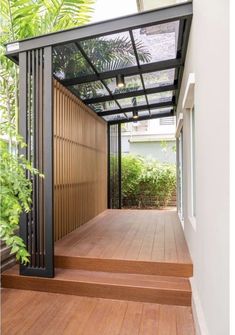 a wooden deck with metal railings next to trees and plants on the other side