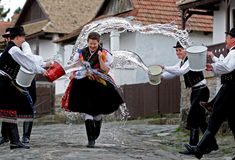 some people are dancing in the street with buckets on their heads and water pouring out of them