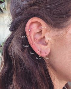 a woman's ear with three different piercings on her left and right side