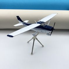 a model airplane sitting on top of a white table next to a blue and white wall