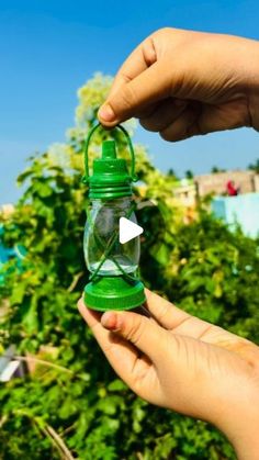 someone is holding a small glass bottle with a green lid and an opening on the top