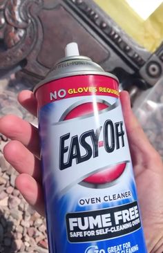 a hand holding a can of easy oil