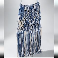 a blue and white bag with fringes hanging from it