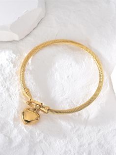 Indulge in timeless elegance with the Lara Heart Bangle. This exquisite bangle features a delicate love lock heart detail, meticulously shaped in the form of a heart. Add a touch of love and sophistication to any outfit with this luxurious piece. Measures: Bracelet, 6cm in diameter. Heart pendant is 17mm tall and 14.2mm wide Luxury Wedding Heart Bracelet With Heart Charm, Luxury Adjustable Heart Bracelet, Elegant Gold Heart-shaped Bangle, Luxury Adjustable Heart-shaped Bracelet, Elegant Heart Bangle Bracelet For Valentine's Day, Elegant Double Heart Charm Bracelets, Elegant Open Heart Bracelet With Heart Charm, Heart-shaped Bracelet With Heart Charm For Promise, Elegant Wedding Charm Bracelet With Heart Charm