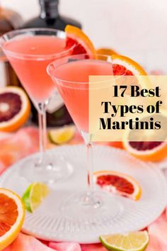 two martinis with grapefruit and orange slices on the rim in front of them