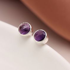 A pair of minimalistic sterling silver February birthstone stud earrings with natural purple amethyst gemstones make the perfect gift for wearers of all ages. Not to be found anywhere on the high street, our beautiful February birthstone studs are crafted from the finest sterling silver. Featuring gorgeous natural purple Amethyst gemstones set in a beautiful silver setting, these dainty silver February birthstone earrings feature a classic butterfly and post fastening and are suitable for almost Everyday Purple Amethyst Earrings, Amethyst Studs, Birthstone Earrings, February Birthstone, Round Stud Earrings, Birthstone Earring, Amethyst Earrings, February Birth Stone, Amethyst Gemstone