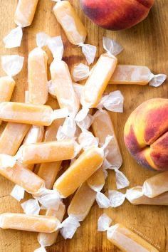 two peaches and one piece of bread on a cutting board with plastic wrappers