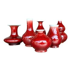 five red vases sitting next to each other in front of a white background,