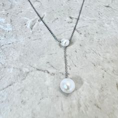 Sterling silver pearl lariat pendant necklace featuring 2 genuine round white freshwater pearls. The larger pearl measures approximately 8.5-9 mm. L: Chain is 18 inches long. Birthstone: June. Condition: Excellent, Brand New. - 14 day return policy, no questions asked. - Free insured shipping in the US. - International shipping available. Note: All items have been appraised and inspected by a jewelry specialist and certified gemologist (GIA GG). All diamond and gemstone gradings are done under G Genuine Pearl Necklace, Pearl Lariat Necklace, Pearl Lariat, June Birthstone, White Freshwater Pearl, Pearl Pendant Necklace, Freshwater Pearl Necklaces, June Birth Stone, Lariat Necklace