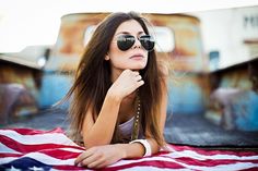 a beautiful young woman laying on top of an american flag