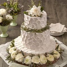 a wedding cake with white flowers and greenery