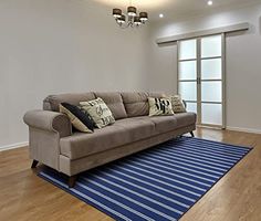 a couch sitting on top of a blue rug in a living room next to a doorway