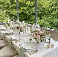 a long table set with white plates and silverware