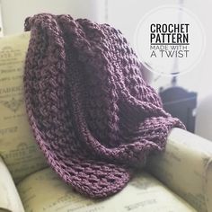 a purple crochet blanket sitting on top of a couch