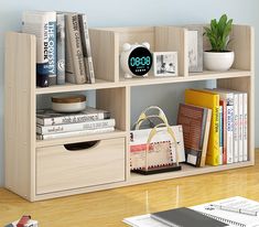 a book shelf filled with books next to a white bag and clock on top of it