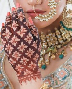 a close up of a woman's hands with hennap on her face