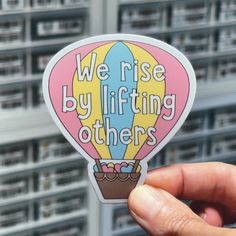 we rise by lifting others sticker in front of some servers with the words, we rise by lifting others