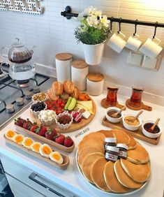 the breakfast is ready to be eaten on the kitchen counter top, including eggs, fruit, and pancakes