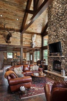 a living room filled with furniture and a stone fireplace